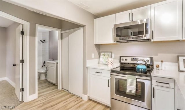 1820 Yale St, North Las Vegas, NV 89030 - kitchen featuring stainless steel appliances, white cabinets, light countertops, and light wood-style flooring
