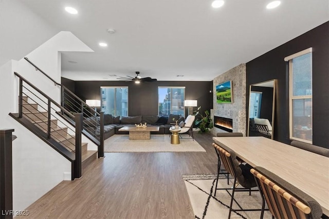 8055 Haywood Estate Ave, Las Vegas, NV 89113 - living room featuring wood finished floors, a large fireplace, recessed lighting, stairs, and a ceiling fan