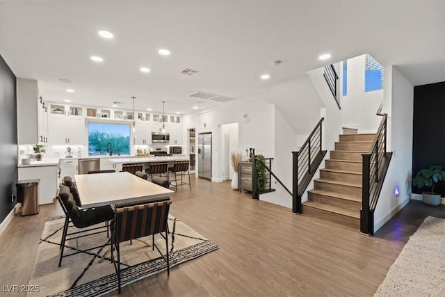 8055 Haywood Estate Ave, Las Vegas, NV 89113 - dining area featuring light wood-style flooring, recessed lighting, and stairway