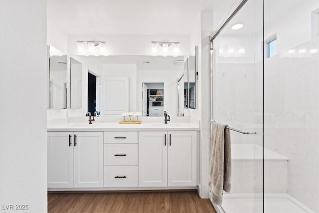 8055 Haywood Estate Ave, Las Vegas, NV 89113 - bathroom featuring double vanity, a stall shower, and wood finished floors