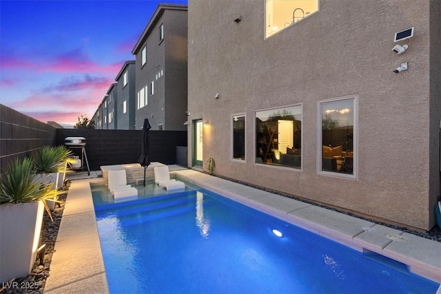 8055 Haywood Estate Ave, Las Vegas, NV 89113 - pool at dusk featuring a fenced backyard and area for grilling