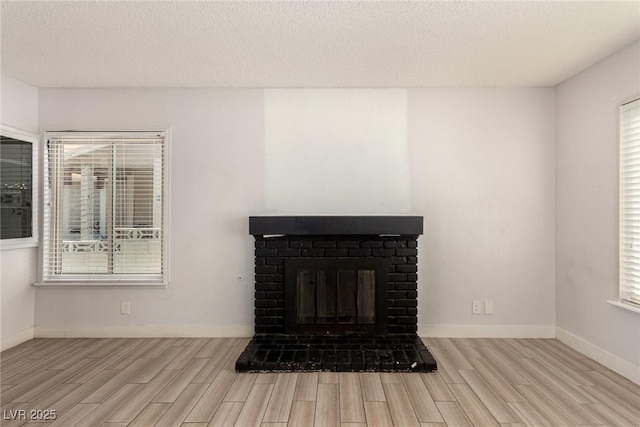 1704 Kismet Cir, Las Vegas, NV 89108 - detailed view of wood finished floors, a fireplace, baseboards, and a textured ceiling