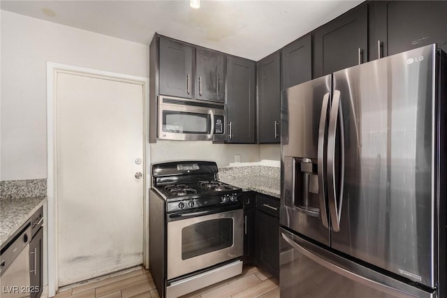 1704 Kismet Cir, Las Vegas, NV 89108 - kitchen with stainless steel appliances, light wood-type flooring, and light stone countertops