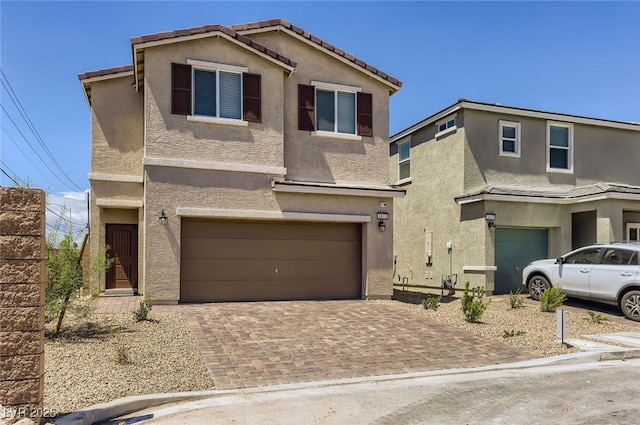 1611 Prairie Fields Ct, Las Vegas, NV 89115 - traditional-style house featuring an attached garage, stucco siding, and decorative driveway