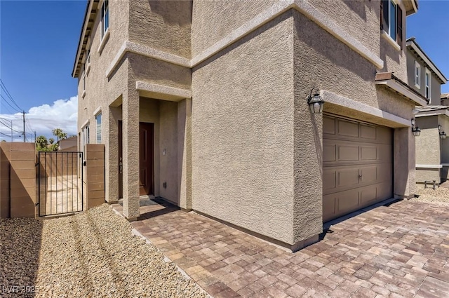 1611 Prairie Fields Ct, Las Vegas, NV 89115 - view of home's exterior featuring a garage, a gate, and stucco siding