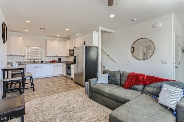 1611 Prairie Fields Ct, Las Vegas, NV 89115 - living room featuring light wood-type flooring, recessed lighting, stairs, and a ceiling fan