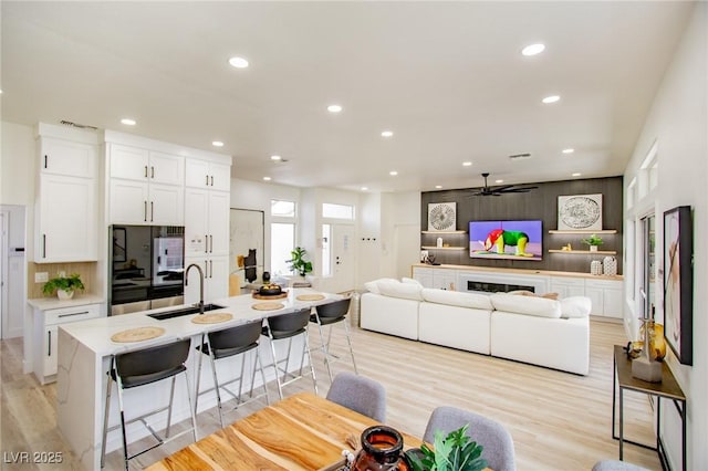 9813 Folsom Dr, Las Vegas, NV 89134 - kitchen featuring a breakfast bar, a ceiling fan, white cabinetry, recessed lighting, and a sink