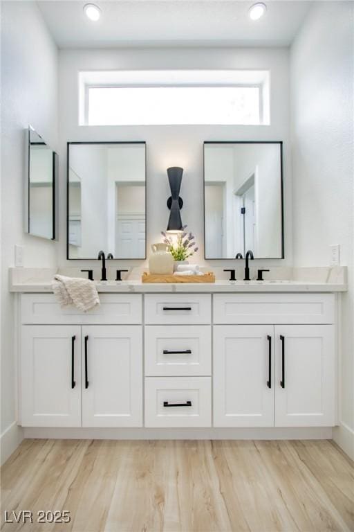 10709 Hunters Woods Pl, Las Vegas, NV 89134 - bathroom with double vanity, wood finished floors, healthy amount of natural light, and baseboards