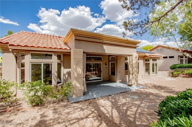10709 Hunters Woods Pl, Las Vegas, NV 89134 - rear view of house featuring stucco siding, a patio area, and a tiled roof