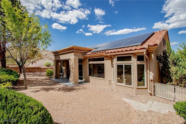 10709 Hunters Woods Pl, Las Vegas, NV 89134 - back of property with stucco siding, solar panels, a tiled roof, and a patio area