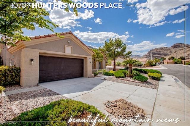 10709 Hunters Woods Pl, Las Vegas, NV 89134 - view of front facade featuring driveway, a mountain view, a garage, a tile roof, and stucco siding