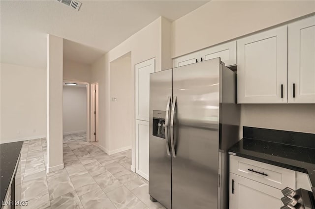 1501 Lucia Dr, Las Vegas, NV 89128 - kitchen with stainless steel refrigerator with ice dispenser, light marble finish floors, white cabinetry, and dark countertops