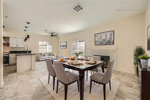 1501 Lucia Dr, Las Vegas, NV 89128 - dining space with ceiling fan, a fireplace, and light marble finish floors