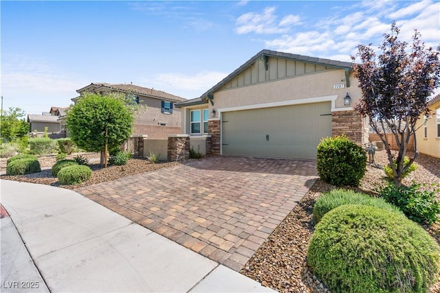 2207 Valdina St, Henderson, NV 89044 - view of front of house with stone siding, board and batten siding, decorative driveway, a garage, and stucco siding