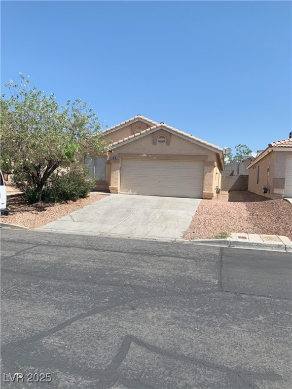 6470 Shining Sand Ave, Las Vegas, NV 89142 - view of front of property with an attached garage, concrete driveway, stucco siding, and a tiled roof