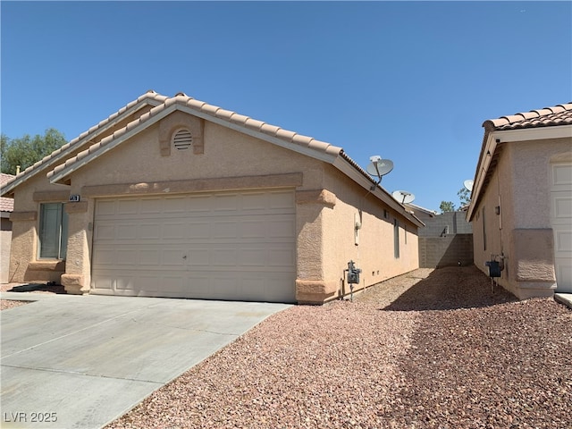 6470 Shining Sand Ave, Las Vegas, NV 89142 - view of front of house with concrete driveway, stucco siding, a tile roof, and a garage