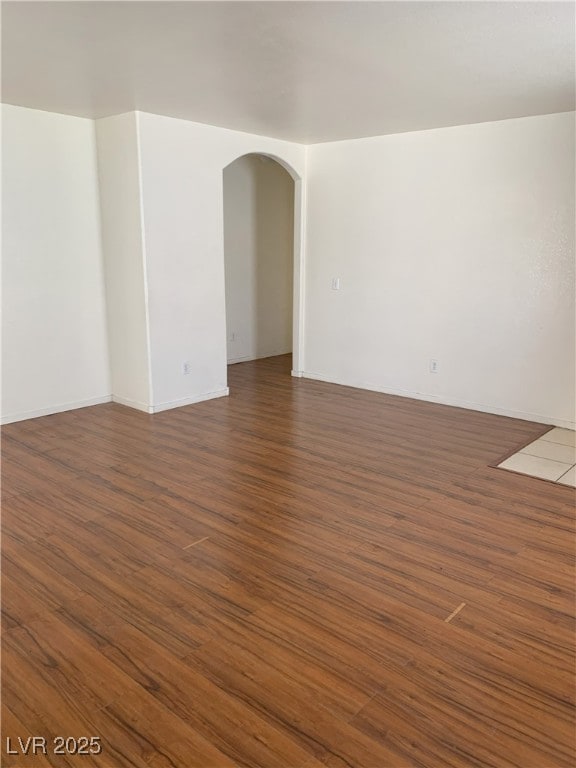 6470 Shining Sand Ave, Las Vegas, NV 89142 - spare room featuring arched walkways and dark wood-type flooring