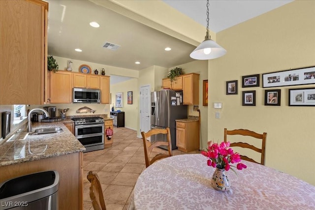 7817 Homing Pigeon St, North Las Vegas, NV 89084 - kitchen featuring appliances with stainless steel finishes, light brown cabinetry, recessed lighting, hanging light fixtures, and light tile patterned floors
