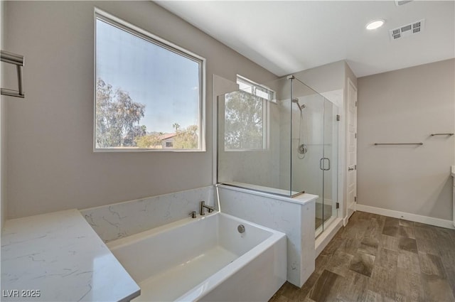 7736 Tioga Ridge Ct, Las Vegas, NV 89117 - bathroom with a garden tub, a shower stall, and wood finished floors