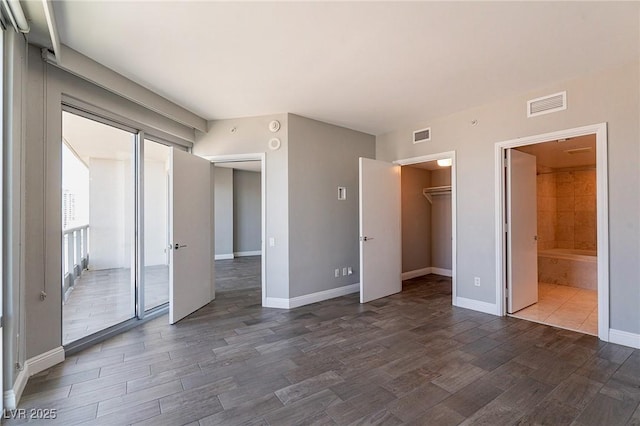 222 Karen Ave Unit 2804, Las Vegas, NV 89109 - unfurnished bedroom with dark wood finished floors, a walk in closet, a closet, and connected bathroom