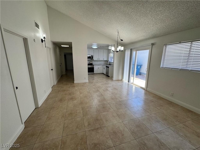 2318 El Molino Cir, Las Vegas, NV 89108 - unfurnished living room featuring a textured ceiling, lofted ceiling, light tile patterned floors, and a chandelier