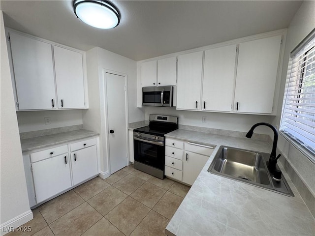 2318 El Molino Cir, Las Vegas, NV 89108 - kitchen with appliances with stainless steel finishes, white cabinets, light tile patterned floors, and light countertops
