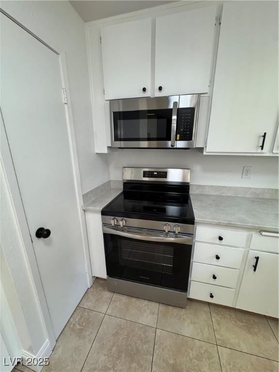 2318 El Molino Cir, Las Vegas, NV 89108 - kitchen with stainless steel appliances, light countertops, white cabinetry, and light tile patterned floors