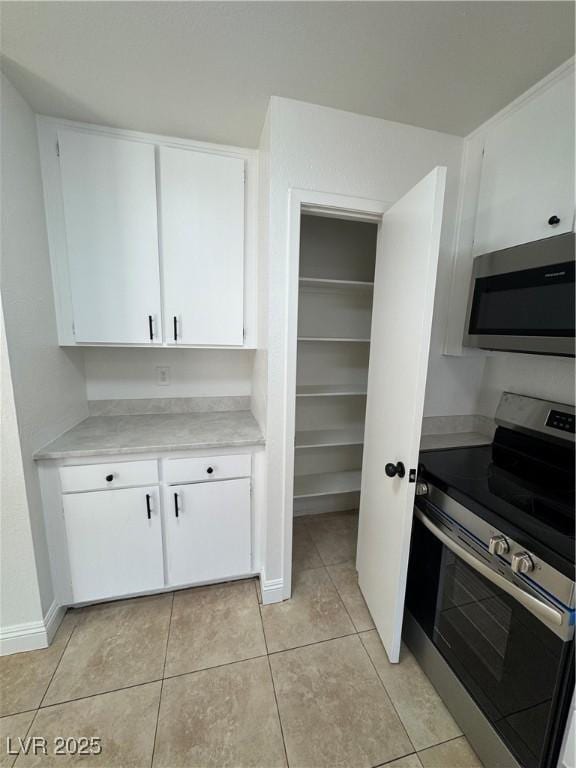 2318 El Molino Cir, Las Vegas, NV 89108 - kitchen with stainless steel appliances, light countertops, white cabinetry, and light tile patterned floors