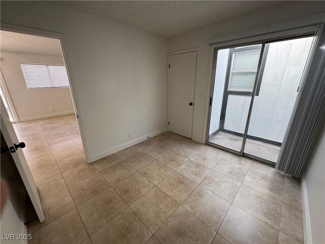 2318 El Molino Cir, Las Vegas, NV 89108 - unfurnished room featuring a textured ceiling, healthy amount of natural light, and light tile patterned floors