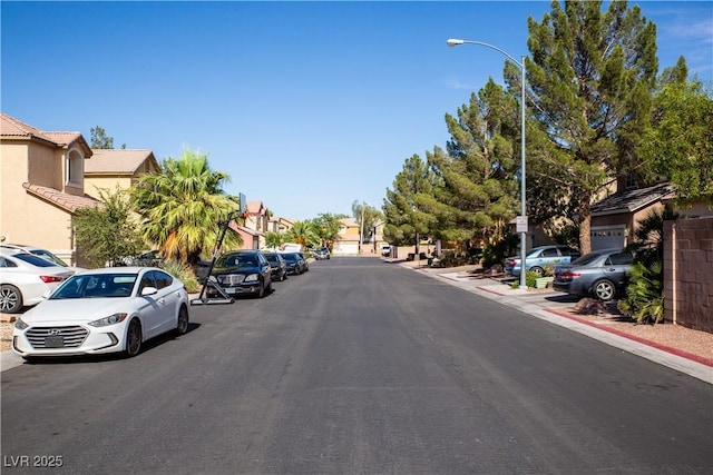 5216 Loma Verde Ave, Las Vegas, NV 89108 - view of asphalt road with street lights, a residential view, curbs, and sidewalks