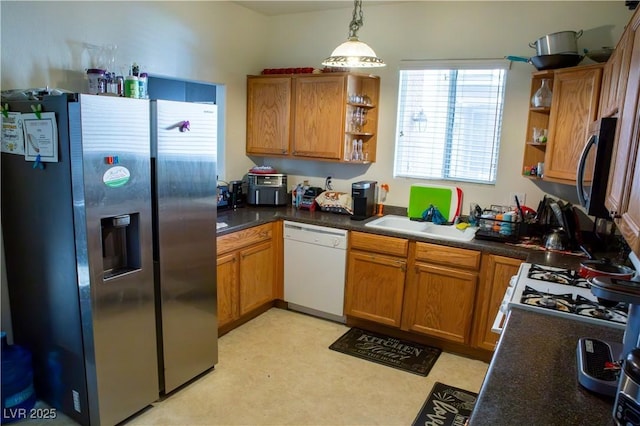 5216 Loma Verde Ave, Las Vegas, NV 89108 - kitchen featuring appliances with stainless steel finishes, open shelves, brown cabinets, hanging light fixtures, and dark countertops