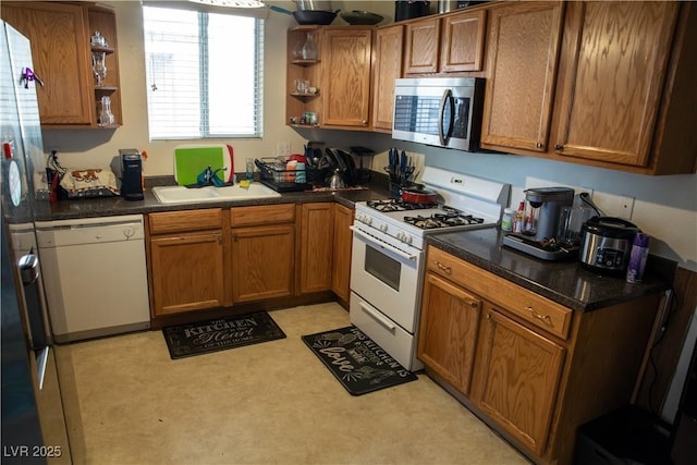 5216 Loma Verde Ave, Las Vegas, NV 89108 - kitchen with white appliances, open shelves, brown cabinetry, and dark countertops