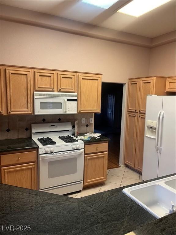 2925 Big Green Ln, Las Vegas, NV 89134 - kitchen featuring white appliances, light tile patterned floors, tasteful backsplash, and dark countertops