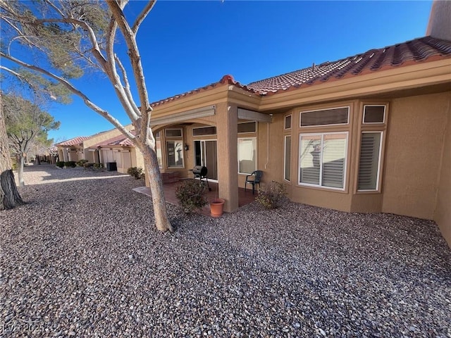 2925 Big Green Ln, Las Vegas, NV 89134 - rear view of house featuring a tile roof, stucco siding, and a patio