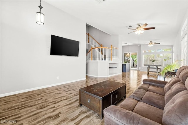 981 Leadville Meadows Dr, Henderson, NV 89052 - living room featuring wood finished floors, ceiling fan, stairway, built in features, and lofted ceiling