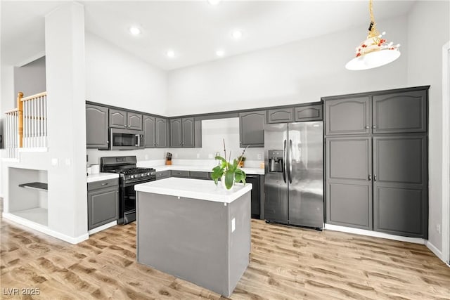 981 Leadville Meadows Dr, Henderson, NV 89052 - kitchen featuring black appliances, a high ceiling, light wood-type flooring, light countertops, and gray cabinets