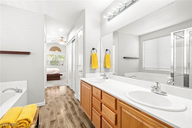 981 Leadville Meadows Dr, Henderson, NV 89052 - ensuite bathroom featuring a bath, wood finished floors, double vanity, a ceiling fan, and recessed lighting
