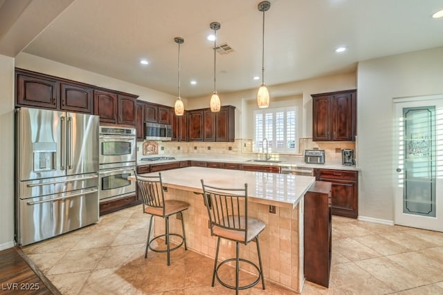 8633 Kennedy Heights Ct, Las Vegas, NV 89131 - kitchen featuring appliances with stainless steel finishes, light countertops, backsplash, dark brown cabinets, and recessed lighting