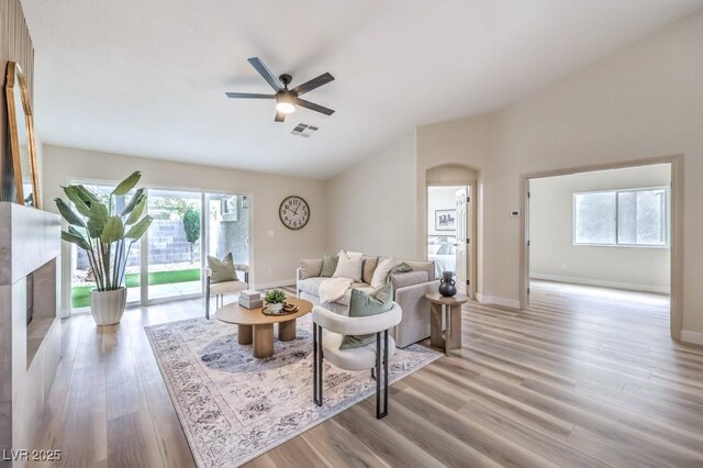 10205 Birch Bluff Ln, Las Vegas, NV 89145 - living room featuring arched walkways, ceiling fan, vaulted ceiling, and light wood-type flooring