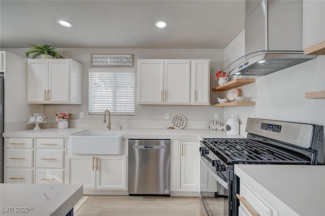 700 Cactus Ln, Las Vegas, NV 89107 - kitchen with appliances with stainless steel finishes, island range hood, light countertops, white cabinetry, and recessed lighting