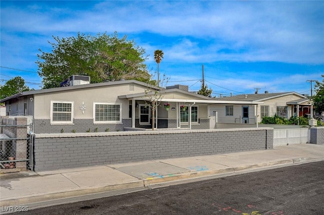 700 Cactus Ln, Las Vegas, NV 89107 - view of front of property with brick siding, a fenced front yard, covered porch, and stucco siding