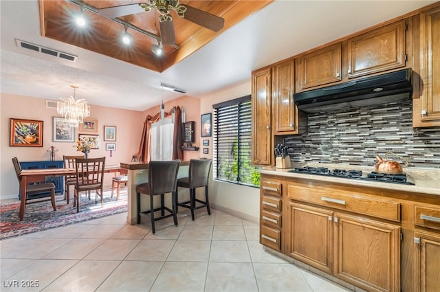 2857 San Lago Ct, Las Vegas, NV 89121 - kitchen featuring exhaust hood, black gas cooktop, track lighting, light tile patterned floors, and light countertops