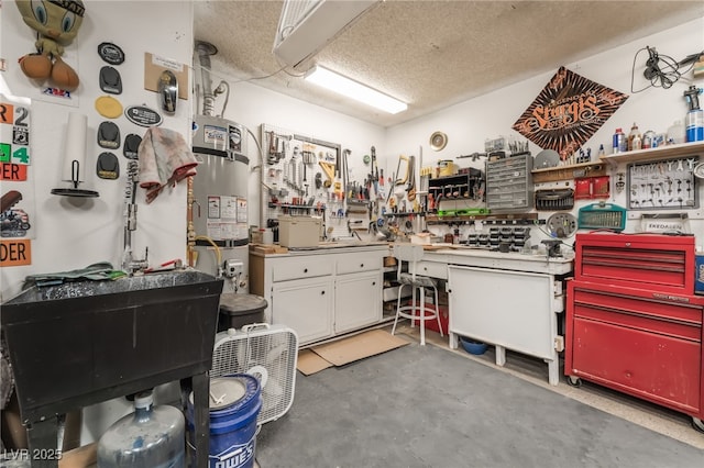 2857 San Lago Ct, Las Vegas, NV 89121 - misc room featuring a workshop area, concrete flooring, strapped water heater, and a textured ceiling