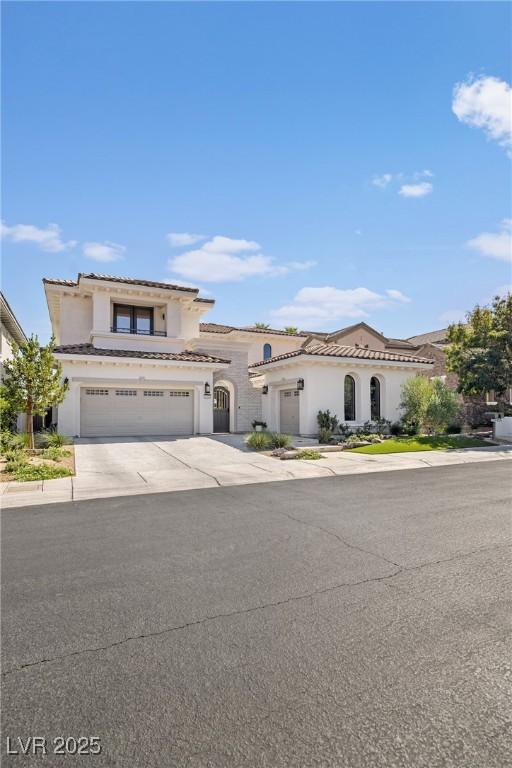 1990 Country Cove Ct, Las Vegas, NV 89135 - mediterranean / spanish house featuring stucco siding, concrete driveway, a tile roof, and an attached garage