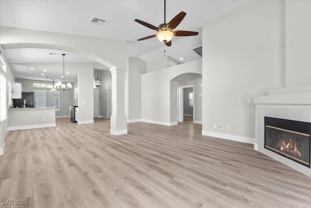 10613 Tiffanieville Ct, Las Vegas, NV 89129 - unfurnished living room with ceiling fan, arched walkways, a tile fireplace, light wood-style flooring, and recessed lighting