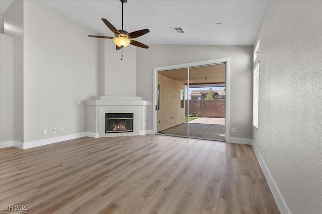 10613 Tiffanieville Ct, Las Vegas, NV 89129 - unfurnished living room with lofted ceiling, wood finished floors, a ceiling fan, and a tiled fireplace