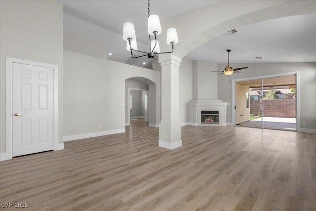10613 Tiffanieville Ct, Las Vegas, NV 89129 - unfurnished living room with ceiling fan, lofted ceiling, arched walkways, a chandelier, and light wood finished floors