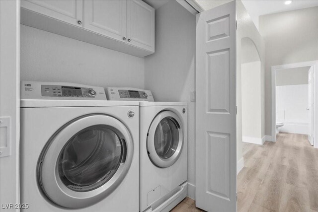 10613 Tiffanieville Ct, Las Vegas, NV 89129 - washroom with cabinet space, washer and clothes dryer, and light wood-style floors
