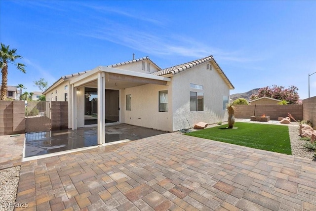 10613 Tiffanieville Ct, Las Vegas, NV 89129 - rear view of house with a fenced backyard, a fire pit, a patio area, stucco siding, and a tiled roof
