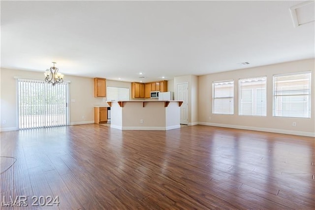 11577 Vesuvio Ct, Las Vegas, NV 89183 - unfurnished living room with wood finished floors, a chandelier, and recessed lighting